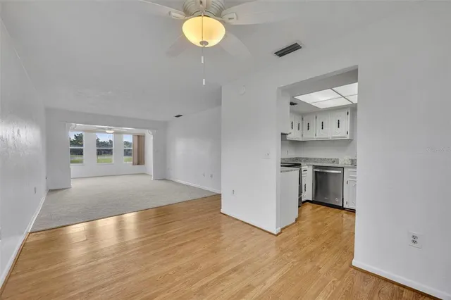 a view of empty room with kitchen and window