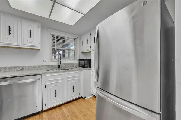 a kitchen with white cabinets and white appliances