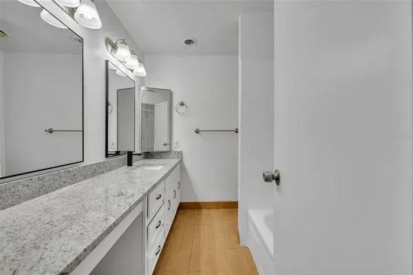 a bathroom with a granite countertop sink a vanity and shower