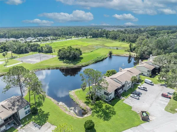 an aerial view of a house with a garden and lake view
