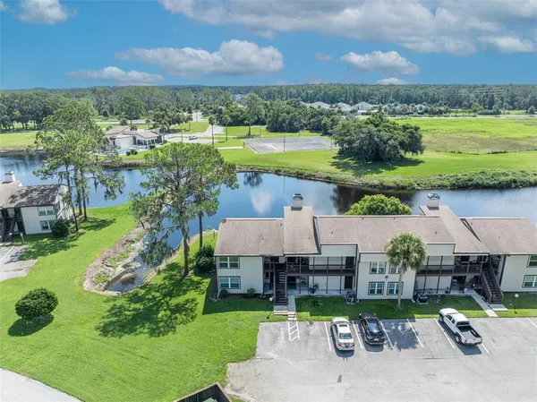 an aerial view of a house with a garden and lake view