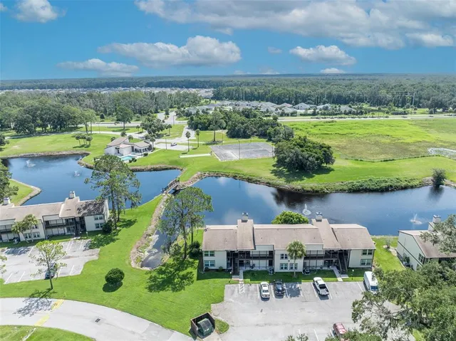 an aerial view of a house with a garden and lake view