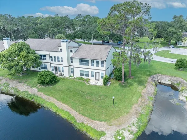 an aerial view of residential houses with outdoor space and trees
