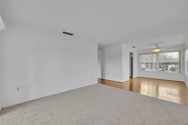 a view of a big room with wooden floor and windows