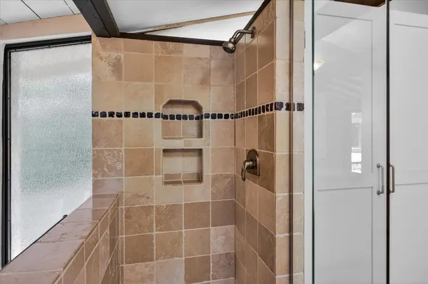 a bathroom with a shower and a glass door