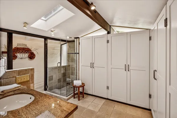 a bathroom with a granite countertop sink toilet and shower