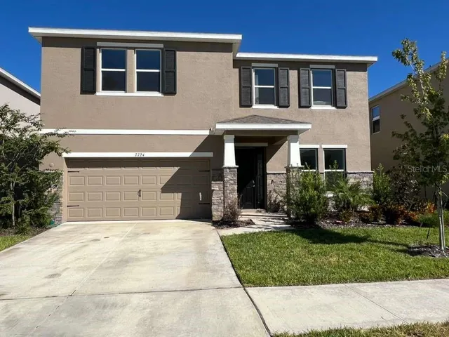 a front view of a house with a yard and garage