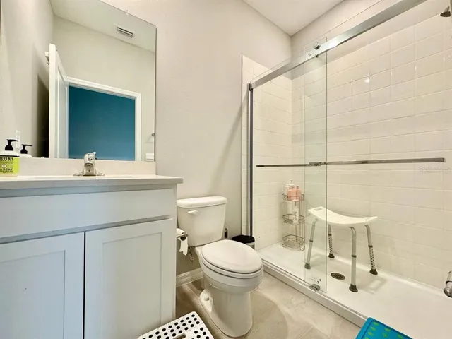 a bathroom with a sink toilet a mirror and shower