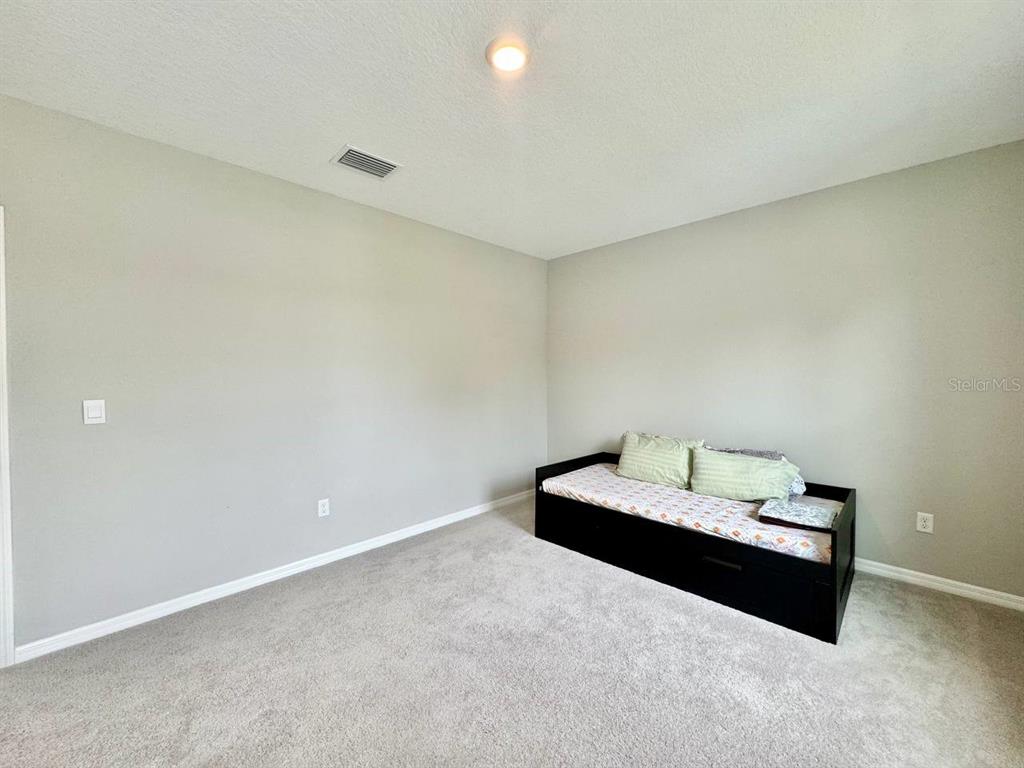 7724 Broad River Avenue Land O Lakes, FL 34638 - Photo 21 of 40 a room with a bed