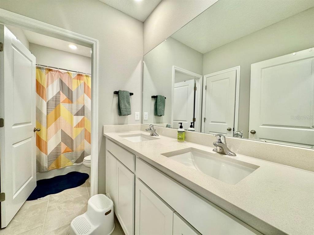 7724 Broad River Avenue Land O Lakes, FL 34638 - Photo 22 of 40 a bathroom with a sink a toilet and a mirror