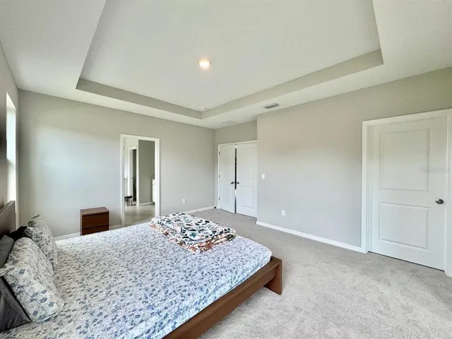 a bedroom with a large bed and a chandelier