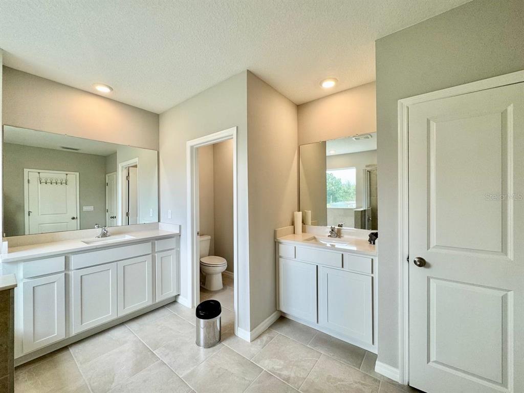 7724 Broad River Avenue Land O Lakes, FL 34638 - Photo 32 of 40 a bathroom with a double vanity sink and mirror