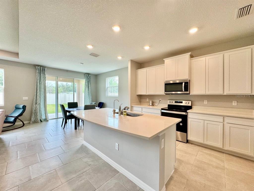 7724 Broad River Avenue Land O Lakes, FL 34638 - Photo 5 of 40 a large white kitchen with stainless steel appliances lots of counter space and breakfast area