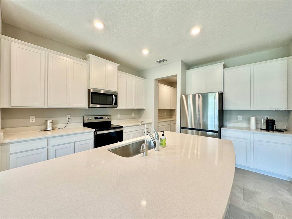 7724 Broad River Avenue Land O Lakes, FL 34638 - Photo 7 of 40 a kitchen with kitchen island a sink stainless steel appliances and cabinets