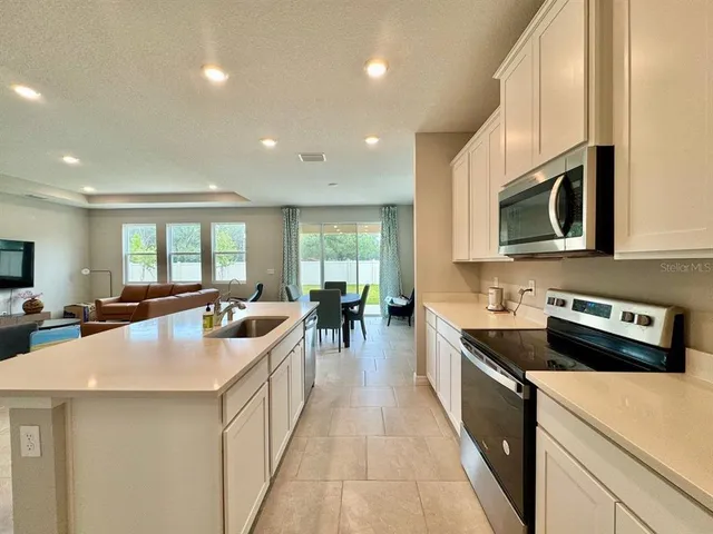 a kitchen with counter top space a sink appliances and cabinets