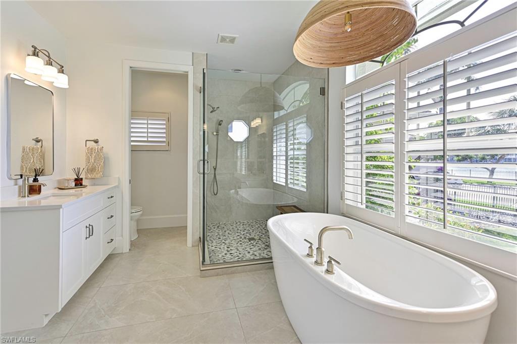 271 Bayview Avenue Naples, FL 34108 - Photo 19 of 35 a bathroom with a bathtub a sink a window and a shower