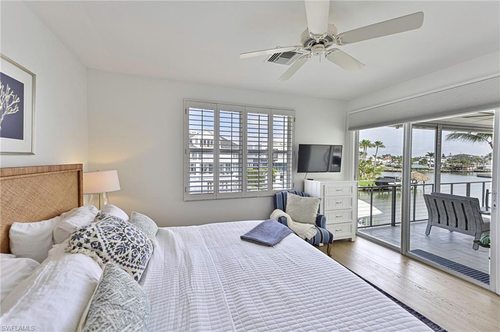 271 Bayview Avenue Naples, FL 34108 - Photo 26 of 35 a bedroom with a large bed and a flat screen tv