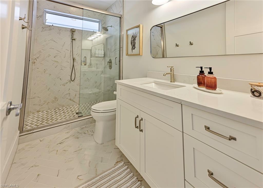 271 Bayview Avenue Naples, FL 34108 - Photo 27 of 35 a bathroom with a shower sink vanity mirror and toilet