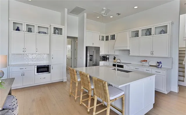 a kitchen that has a lot of cabinets in it and stainless steel appliances