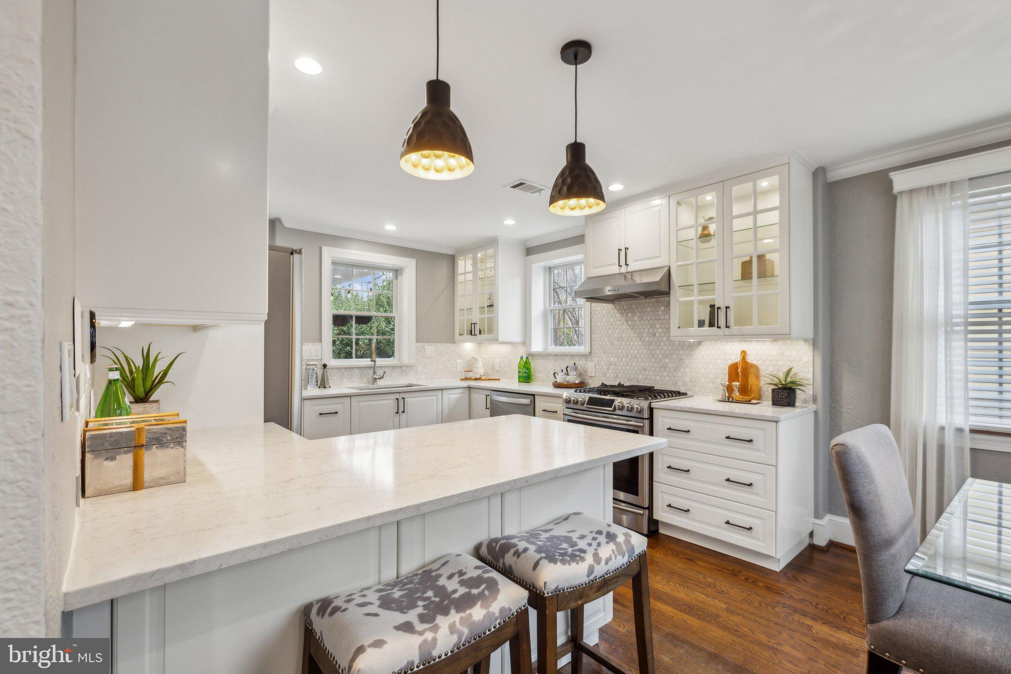 3808 North Pershing Drive Arlington, VA 22203 - Photo 2 of 42 a kitchen with stainless steel appliances a stove a sink a dining table and chairs with wooden floor
