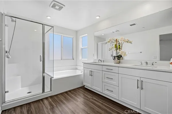 a spacious bathroom with a double vanity sink a mirror and a shower