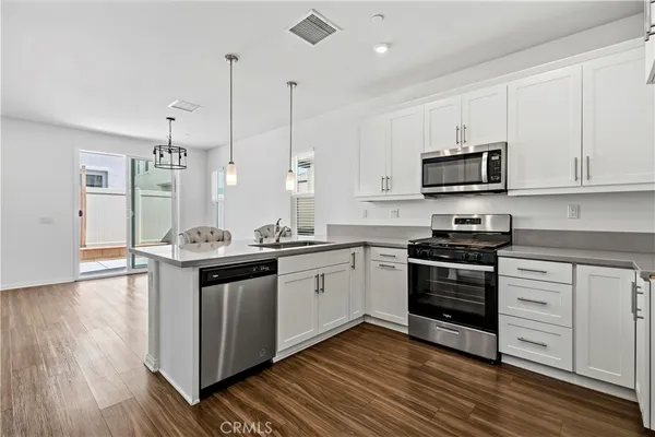 a kitchen with stainless steel appliances kitchen island granite countertop a stove a sink and a microwave