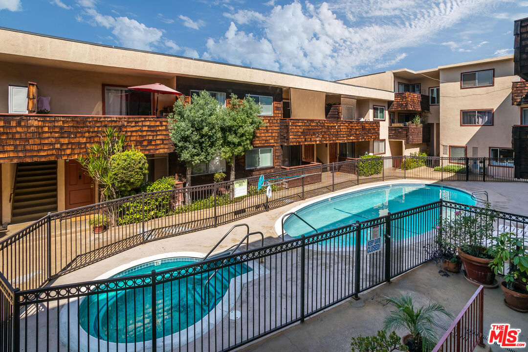 5414 Newcastle Avenue, Unit 50 Encino, CA 91316 - Photo 21 of 23 a balcony with tall trees in front of it