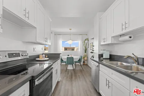 a kitchen with stainless steel appliances granite countertop a sink dishwasher stove and refrigerator