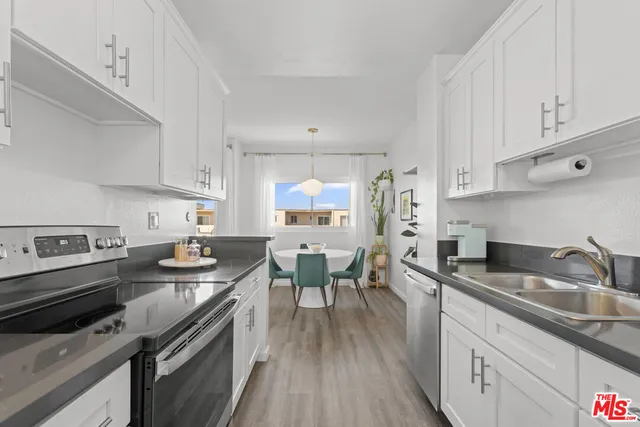 a kitchen with stainless steel appliances granite countertop a sink dishwasher stove and refrigerator