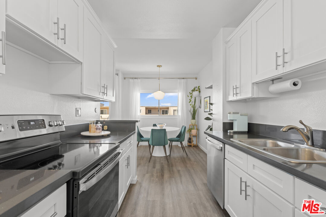 5414 Newcastle Avenue, Unit 50 Encino, CA 91316 - Photo 3 of 23 a kitchen with stainless steel appliances granite countertop a sink dishwasher stove and refrigerator