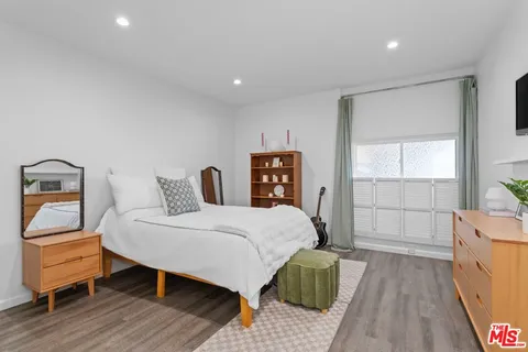 a bedroom with a bed and wooden floor