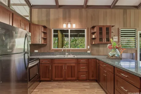 a kitchen with stainless steel appliances granite countertop a sink and a stove