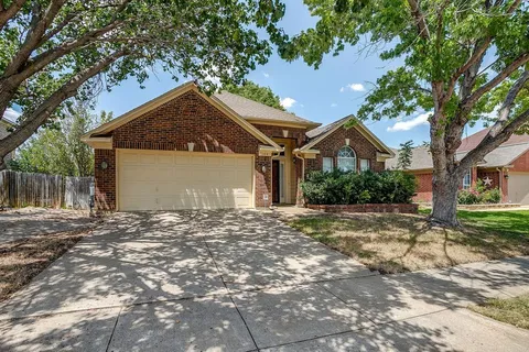 a view of a house with a yard and large tree
