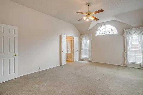 an empty room with fan and windows