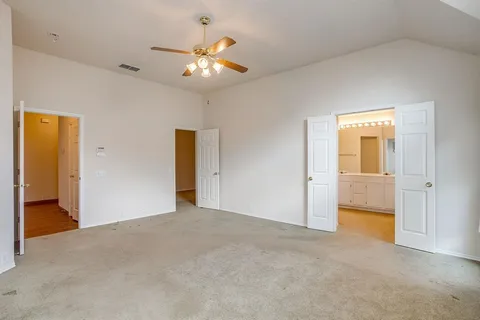 a view of an empty room with a chandelier fan