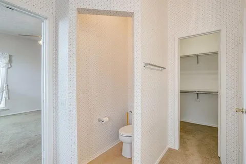 a bathroom with a granite countertop toilet and a sink