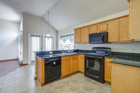 a kitchen with stainless steel appliances granite countertop a stove a sink and a microwave