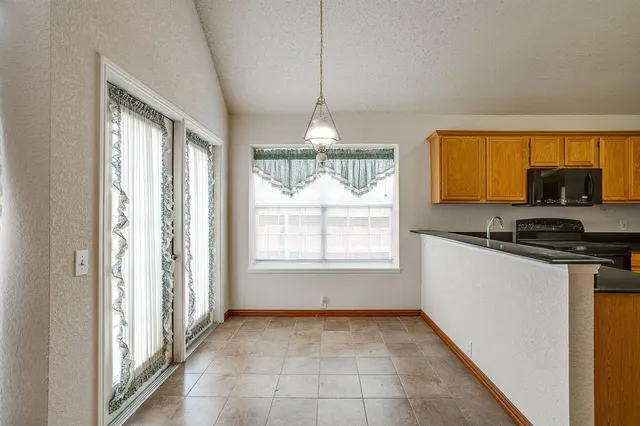 a kitchen that has a lot of windows and cabinets