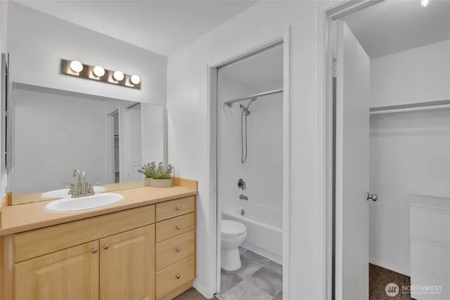 a bathroom with a double vanity sink mirror and toilet