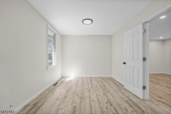 a view of a room with wooden floor and a window