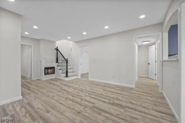 a view of a hallway with wooden floor and a fireplace