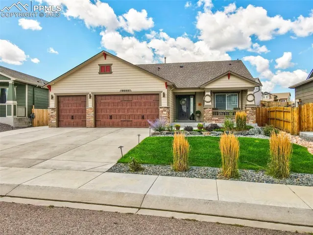 a front view of a house with a yard and potted plants