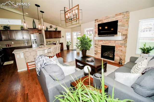 a living room with furniture a flat screen tv and a fireplace