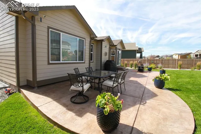 a view of a patio with table and chairs and a garden