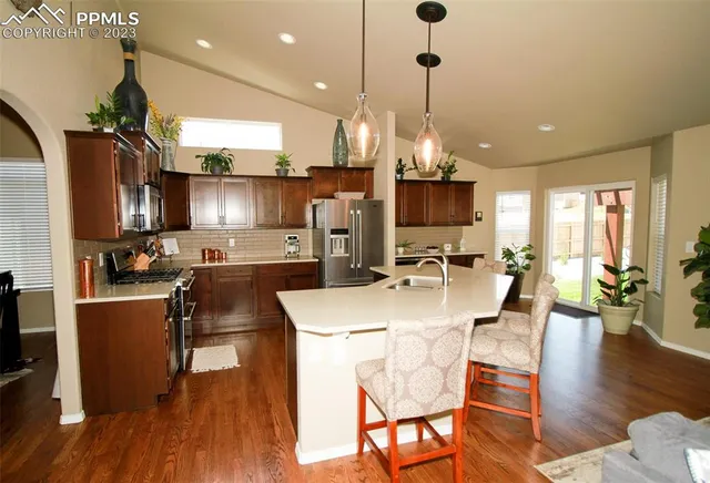 a view of a dining room and livingroom with furniture wooden floor a chandelier