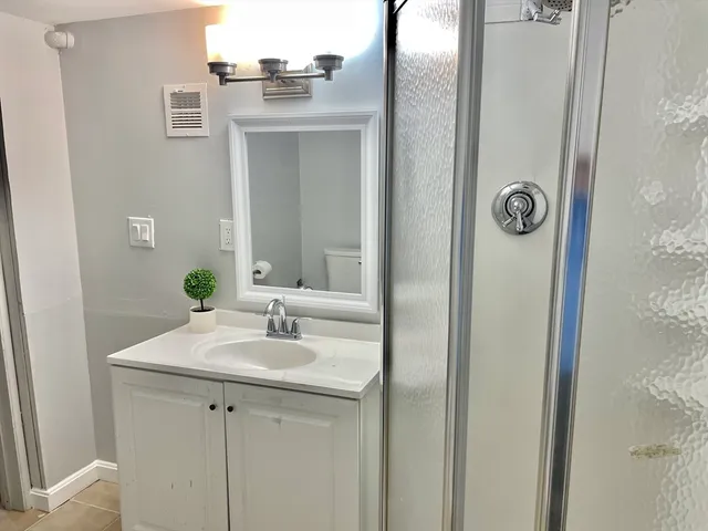 a bathroom with a sink vanity and a mirror