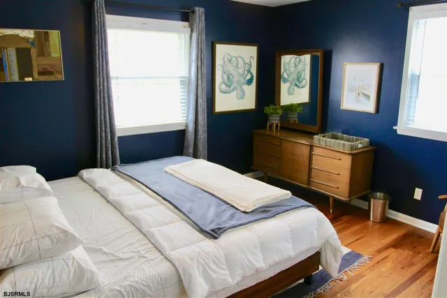 a bedroom with a bed and a dresser next to a window