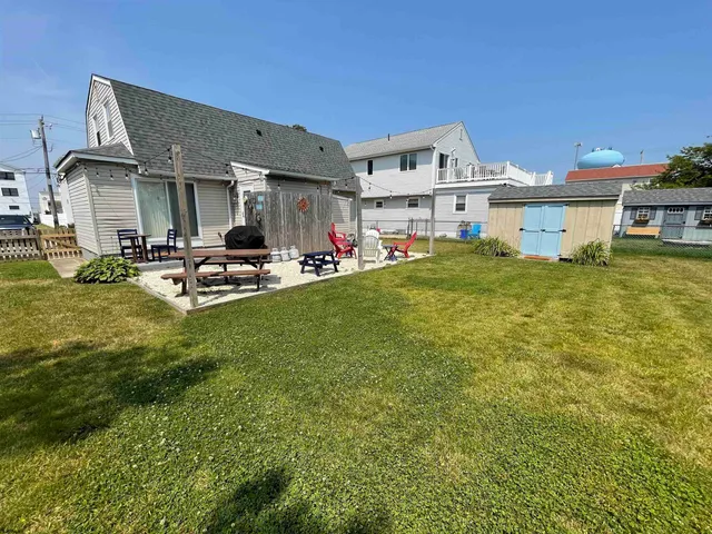 a view of a house with a patio and a yard