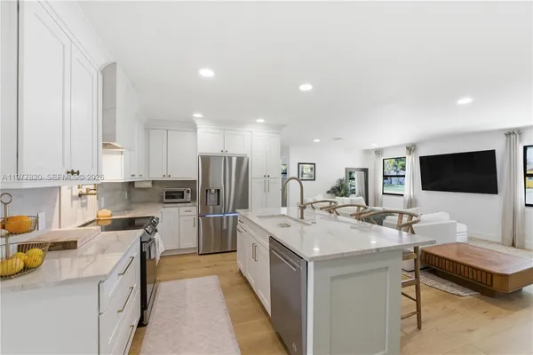 a kitchen with a sink a counter top space stainless steel appliances and cabinets