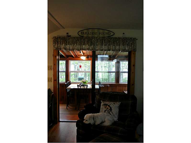 108 Sanctuary Road Charlestown, RI 02813 - Photo 13 of 23 Living Room. Living area looking into porch area. The cute little dog does NOT stay with the house. You need to bring your own pets!